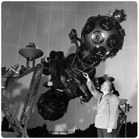 Black and white photo of man in suit with Zeiss Projector